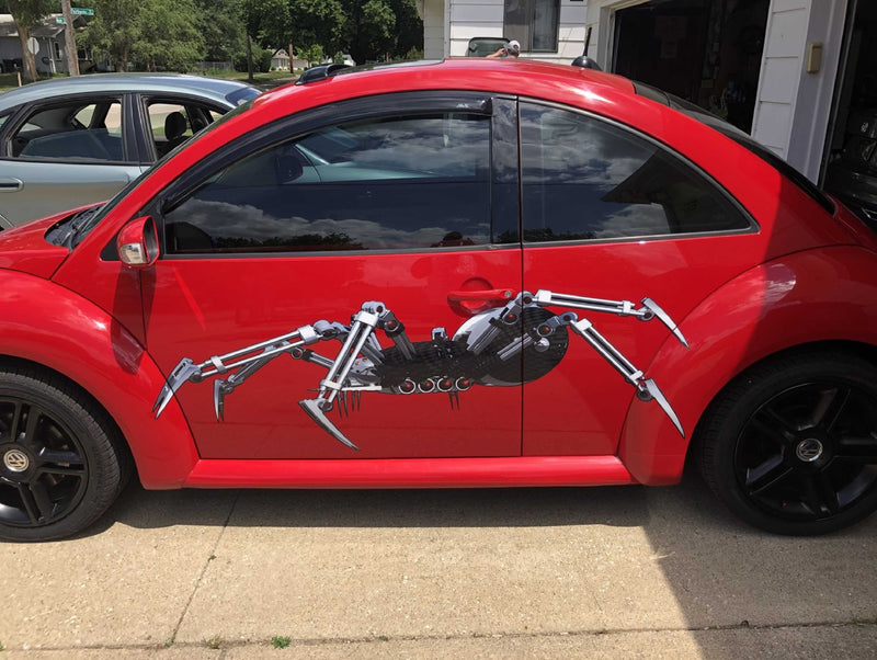 Robot spider decals on the side of red vw beetle car